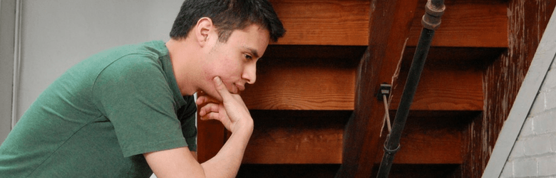 man thinking feeling anxious by stairwell