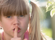 little girl with finger on her lips in quiet environment