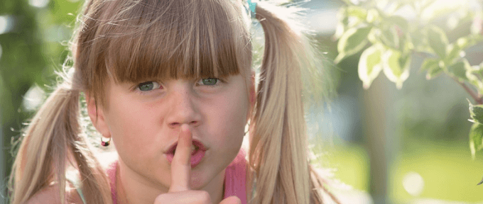 little girl with finger on her lips in quiet environment