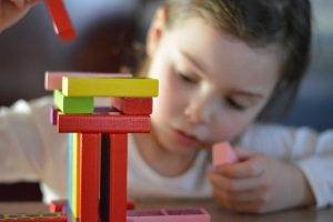 little girl playing with toy bricks