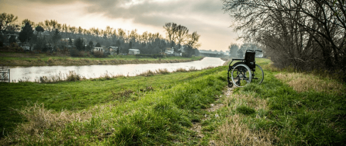 abandoned wheelchair on the field by the river
