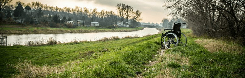 abandoned wheelchair on the field by the river