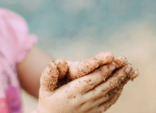 little girl with sand on her sands