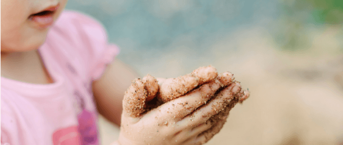 little girl with sand on her sands