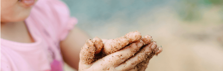 little girl with sand on her sands