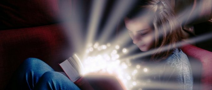 young girl reading a book looking magical
