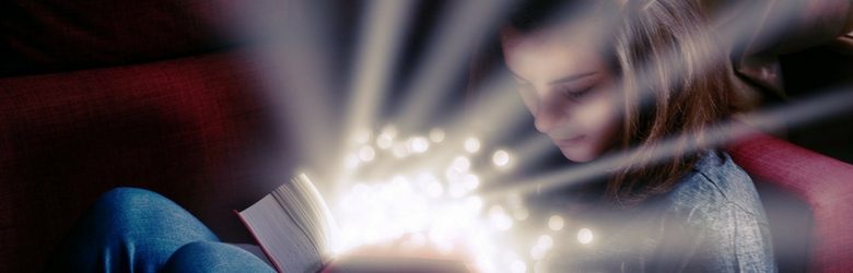 young girl reading a book looking magical