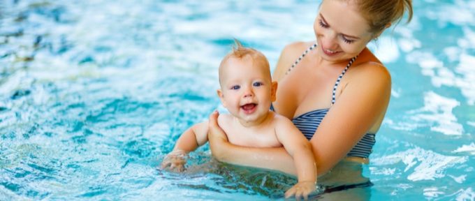 baby swimming in pool with their parent