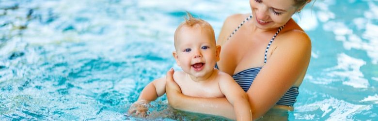 baby swimming in pool with their parent