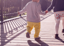 two children walking across a bridge