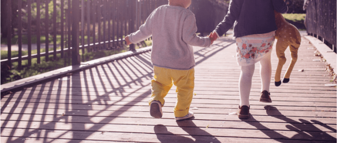 two children walking across a bridge