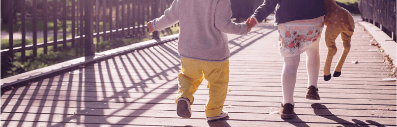 two children walking across a bridge